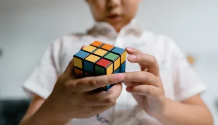 Photo of a child playing with rubiks cube